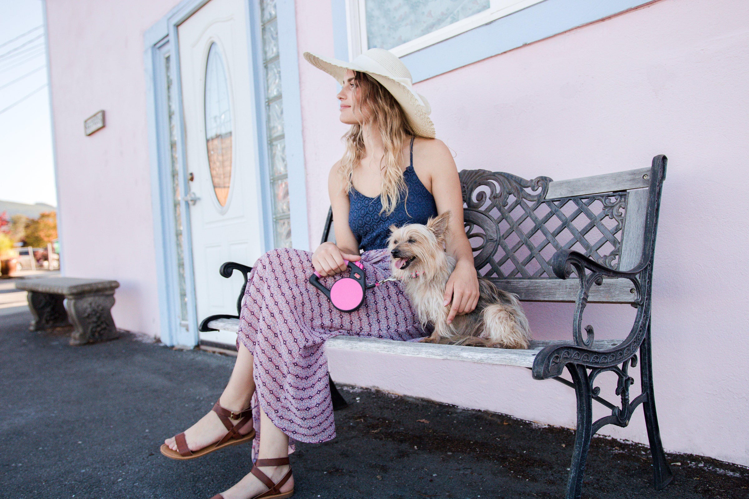 Woman sitting with small dog using Wigzi Retractable Dog Leash with Gel Handle in Pink