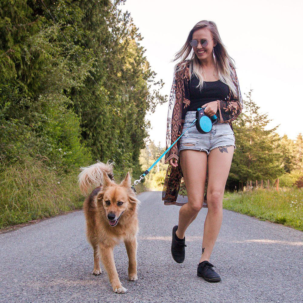 Woman walking dog with Wigzi Retractable Dog Leash with Gel Handle in Blue